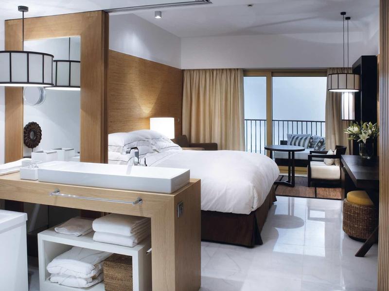 Moderner Bürokomplex mit vielen Fenstern, umgeben von Palmen und blauer Himmel im Hintergrund.