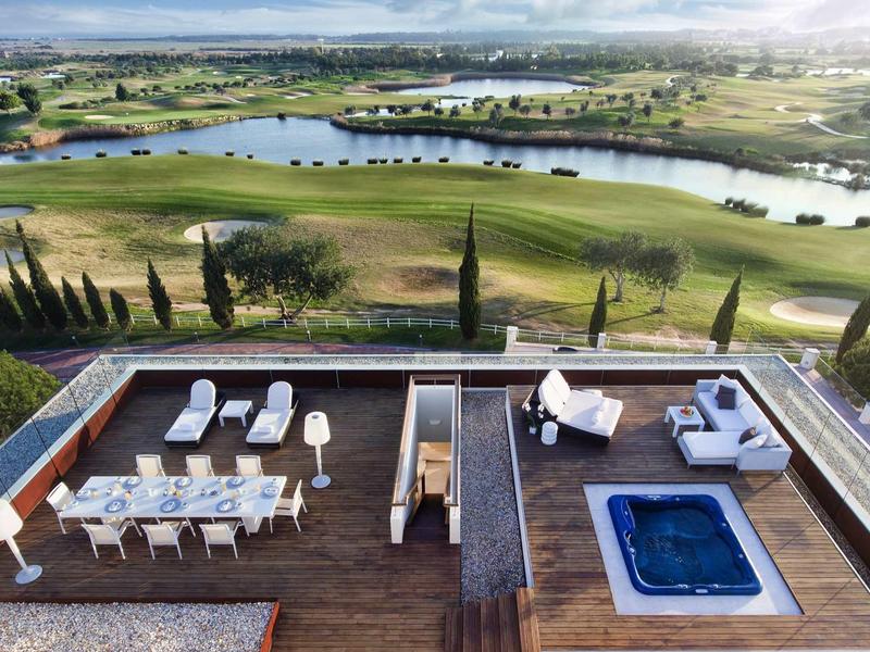 Moderner Dachgarten mit Whirlpool, Sitzgruppen und weitem Blick auf Golfplatz und Wasserlandschaft.