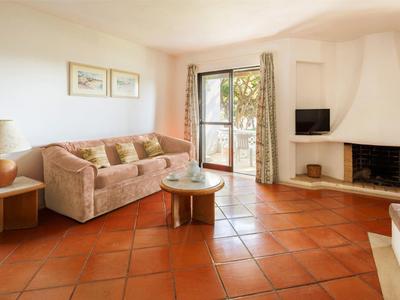 Gemütliches Wohnzimmer mit Sofa, Kamin und Zugang zum Balkon in einem Ferienhaus.