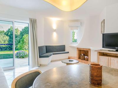 Helles Wohnzimmer mit raumhohen Fenstern, integriertem Sitzbereich und modernem Kamin