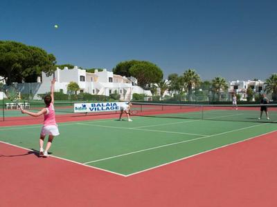 Helles Hotelzimmer mit zwei Einzelbetten, Fenster und Schreibtisch mit Stuhl.