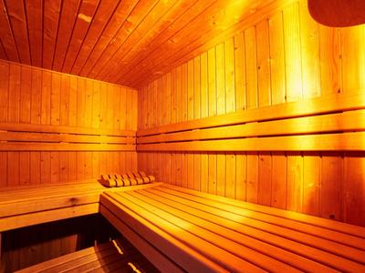 Dřevěná sauna s víceúrovňovými lavicemi a teplým osvětlením