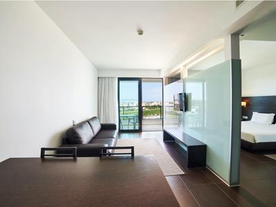 Moderní hotelový pokoj s posezením a výhledem na terasu a přírodu