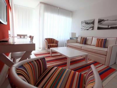 Soggiorno moderno con tessuti a righe colorate e molta luce naturale.