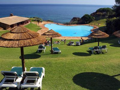 Vista di una piscina con lettini e ombrelloni vicino al mare in una giornata di sole