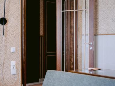 Modernes Hotellobby-Interieur mit hellblauem Sofa, Glaswand und Stehleuchte.