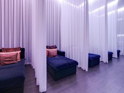 Hotel-Wellnessbereich mit einzelnen Liegen, umgeben von durchsichtigen weißen Vorhängen.
