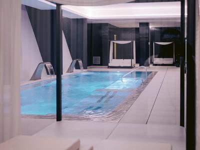 Moderner Innenpool mit klarem Wasser und stilvollen Liegen für Entspannung im Hotel.