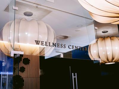 Moderne Wellness-Center-Eingang mit Glas und großen, runden Leuchten.