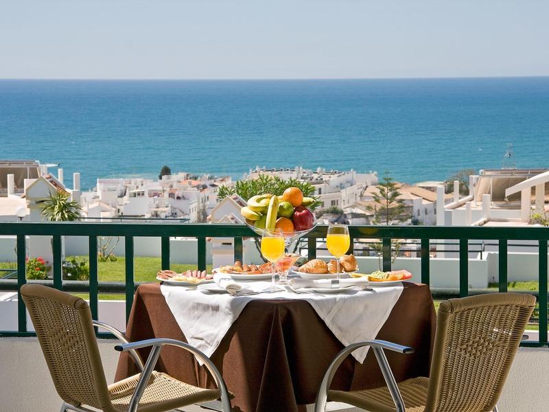 Widok na nakryty stół na balkonie z widokiem na morze i wschód słońca.