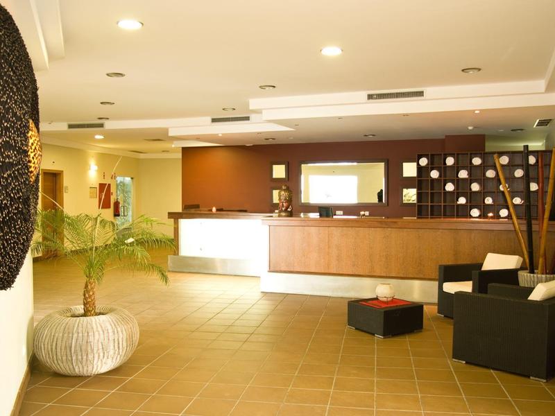 Jasne i nowoczesne lobby hotelowe z recepcją, miejscem do siedzenia i dekoracyjną sztuką ścienną.