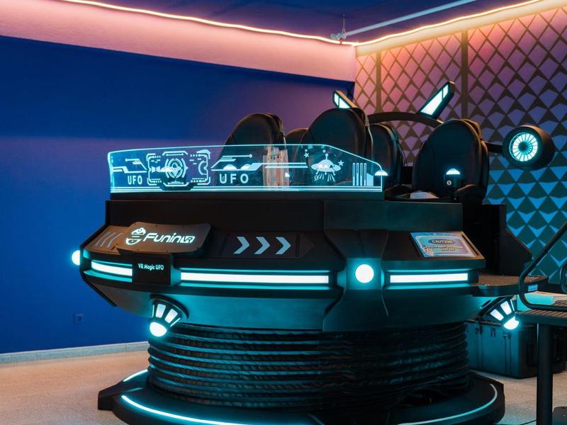 Console DJ moderna con display luminosi in una stanza futuristica con illuminazione blu.