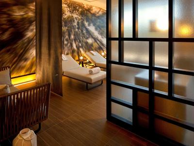 Interno di hotel moderno con lounge accogliente, sedute eleganti e illuminazione calda.