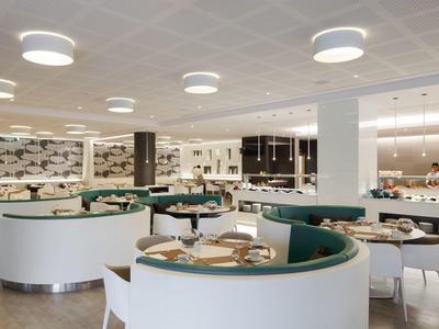 Ristorante d'hotel moderno con aree salotto semicircolari e design luminoso ed elegante.