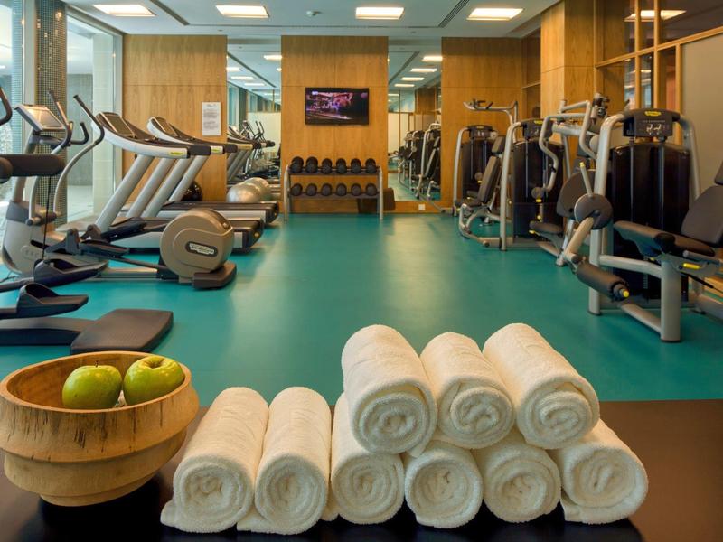 Palestra in hotel con attrezzi per esercizi, asciugamani arrotolati e frutta.