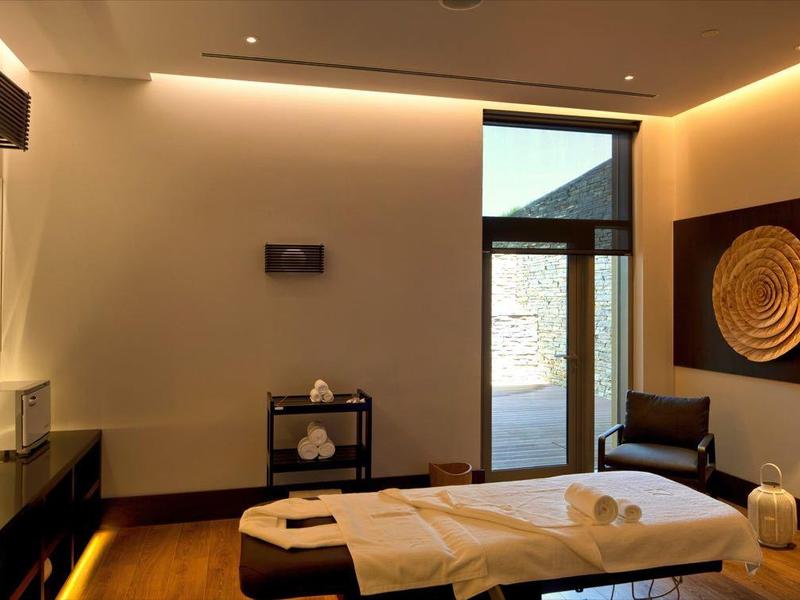 Camera d'hotel moderna con letto matrimoniale, illuminazione indiretta e due grandi decorazioni murali.