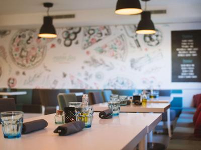 Modern eingerichteter Essbereich mit dekorativen Wandmustern und gedeckten Tischen.