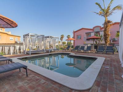 Ein beheizter Pool mit Umgebungsbereichen und Sitzplätzen bei klarem Wetter.