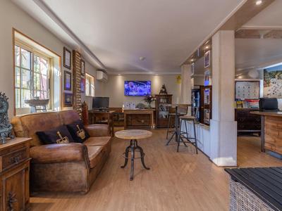 Gemütlicher Hotel-Lounge-Bereich mit Ledersofas, Holzmöbeln und Fernseher an der Wand.