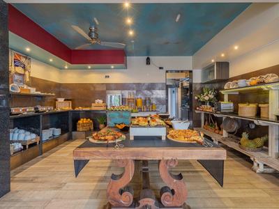 Buffetbereich mit einer Auswahl an Backwaren in einem Hotelrestaurant mit warmem Licht und moderner Einrichtung.