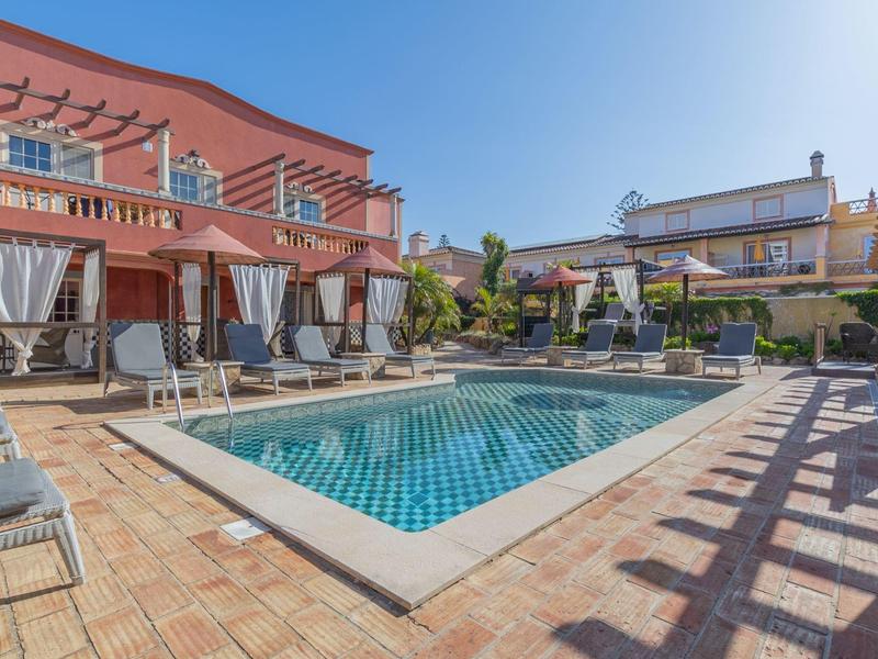 Moderner Außenpoolbereich mit Liegestühlen und Sonnenschirmen in einem Hotel