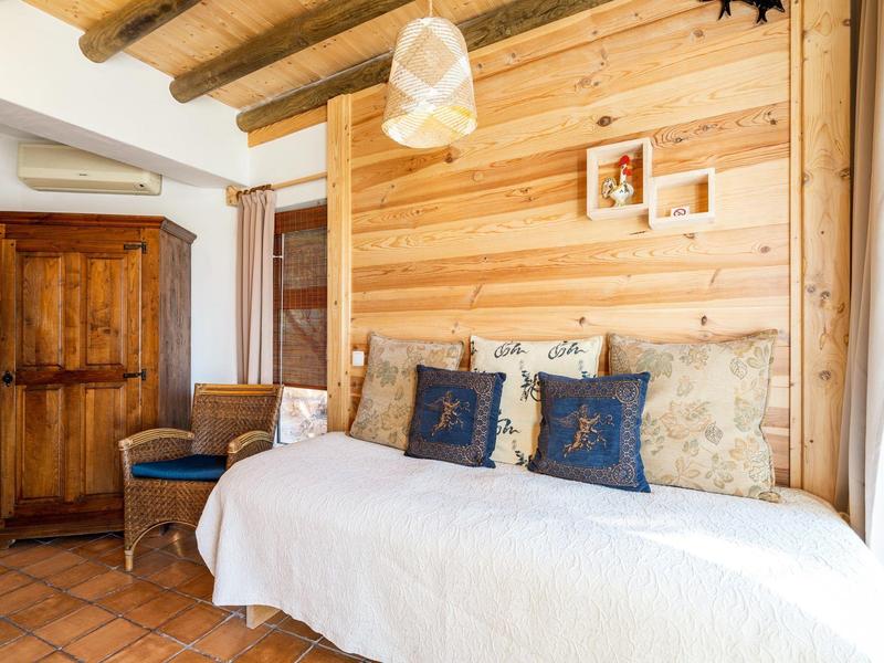 Helles, gemütliches Zimmer mit Holzwänden, Sofa und rustikalem Schrank.