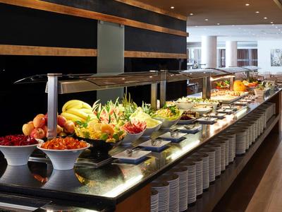 Buffet mit verschiedenen Früchten und Speisen in einem Restaurant mit modernem Design
