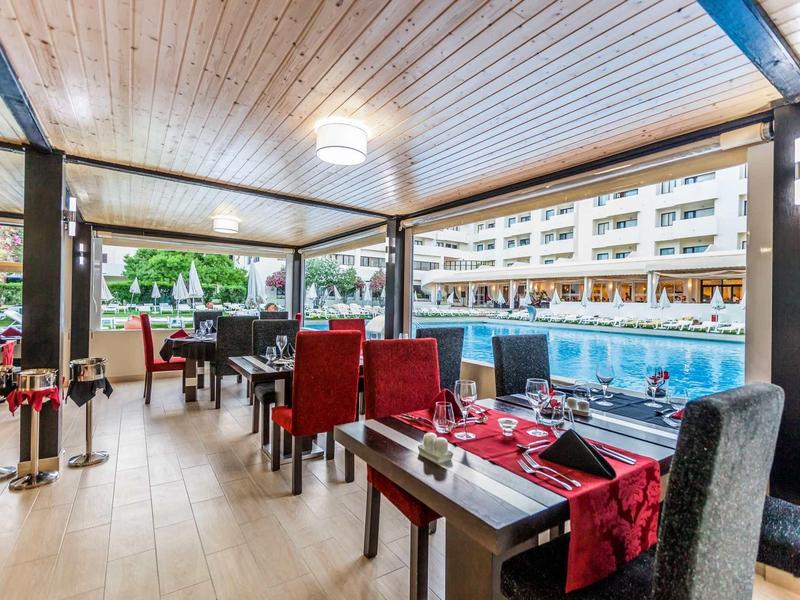 Gemütlicher Wellnessraum mit blauen Whirlpool, dunklen Holzwänden und entspannenden Sesseln.