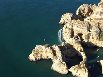 Felsformationen mit natürlichen Bögen über blauem Meerwasser unter sonnigem Himmel.