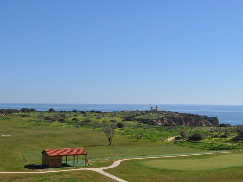 Kinderspielplatz mit Rutsche, Wippe, Klettergerüst und Gebäude mit bunter Wandgestaltung.