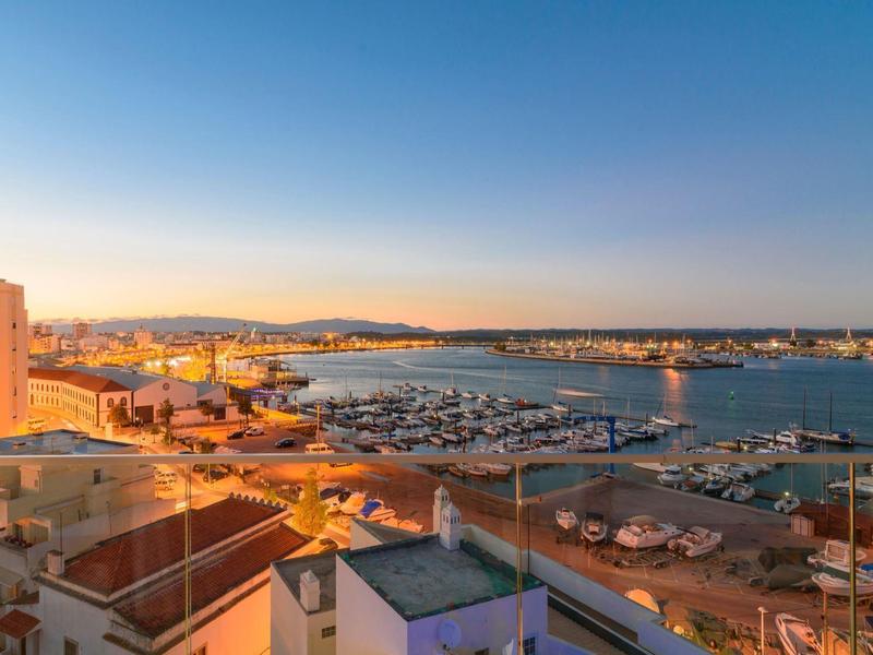 Pohled na přístav s loděmi a budovami při západu slunce