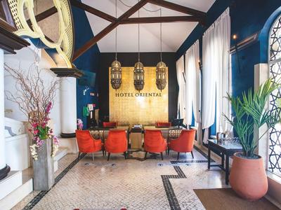 Elegante hotellobby met rode stoelen, grote ramen en oosterse decoratie