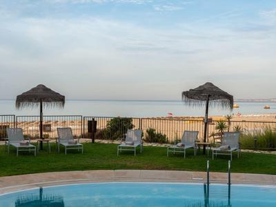 Piscine avec eau bleue et parasols au bord sous un ciel clair