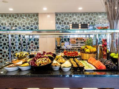 Buffet avec différents fruits et pâtisseries dans un restaurant d'hôtel.
