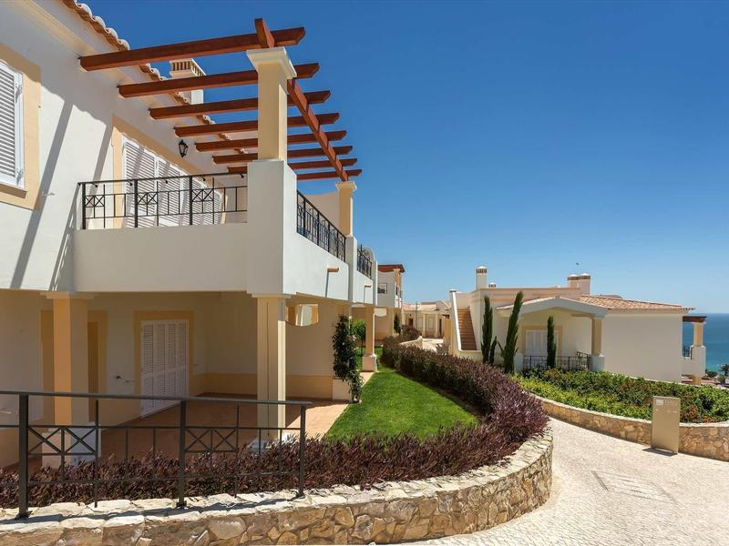 Complexe de bâtiments modernes avec terrasse et vue sur la mer sous un ciel dégagé