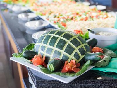 Creatief versierde komkommers op een bord met gesneden patronen en groentegarnituur.