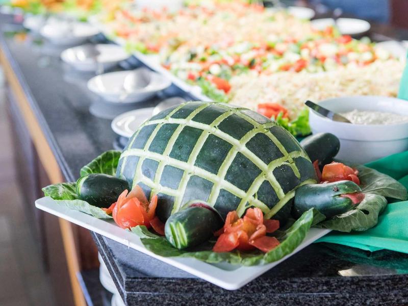 Creatief versierde komkommers op een bord met gesneden patronen en groentegarnituur.