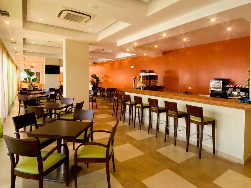 Moderne hotelbar met lange tafel en zitplaatsen onder warm licht.