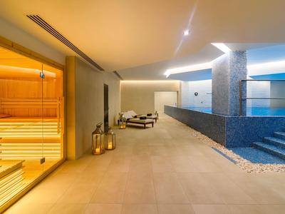 Moderne wellnessruimte met sauna en zwembad in warm licht.