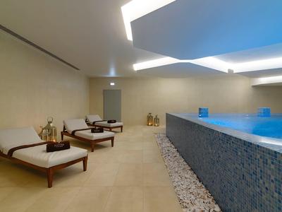 Moderne wellnessruimte met zwembad en houten meubels langs de muur.