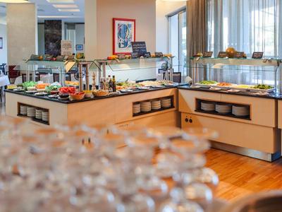 Buffetgedeelte in een helder hotelrestaurant met diverse gerechten op toonbanken.