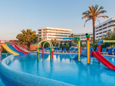 Waterpark met glijbanen en waterspeeltoestellen voor hotelgebouwen bij heldere lucht.
