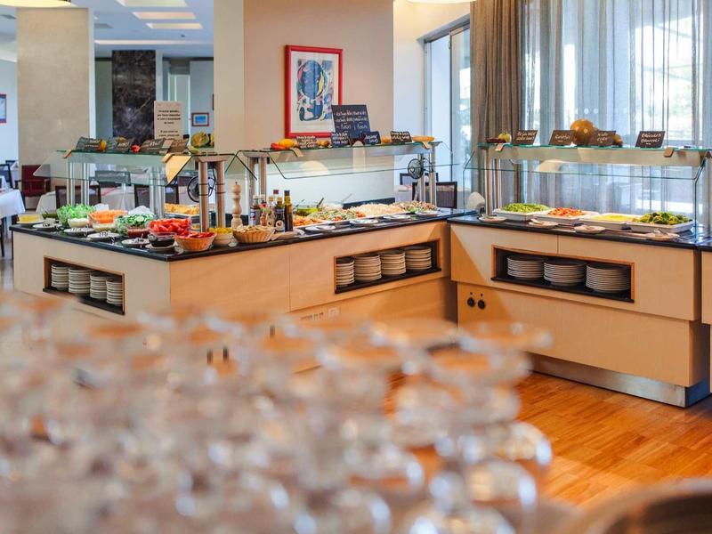 Buffetgedeelte in een helder hotelrestaurant met diverse gerechten op toonbanken.