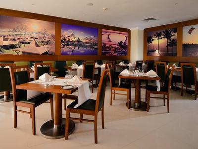 Elegantes Restaurant mit gedeckten Tischen und stilvollen Holzmöbeln an den Wänden.
