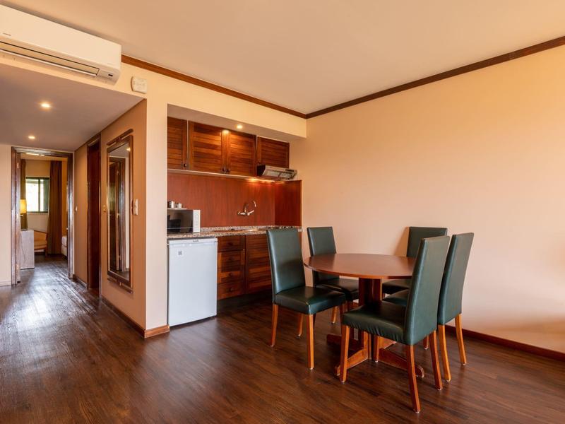 Moderner Essbereich mit vier Stühlen und angrenzender offener Küche.