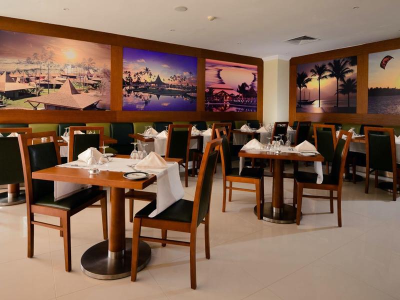 Elegantes Restaurant mit gedeckten Tischen und stilvollen Holzmöbeln an den Wänden.