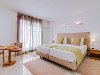 Licht hotelkamer met twee eenpersoonsbedden en zithoek bij het raam