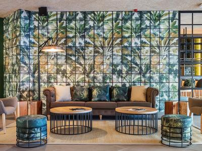 Moderní lounge s pohovkou, konferenčními stolky a vzorovanou stěnou.