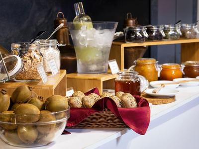 Buffet mit verschiedenen Früchten, Marmeladen und Frühstückszutaten auf einer Theke.