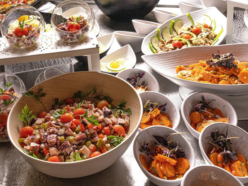 Ensaladas coloridas y postres en cuencos, dispuestos para un buffet en un restaurante.